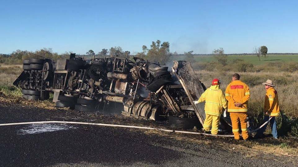 WRECKAGE: Fire crews work to hose down the smouldering truck following the head-on collision just north of Gurley, on July 8. Photo: Live Traffic NSW