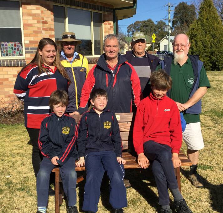 TEAMWORK: Men’s Shed’s Bob, Bruce and Reg, Red Range principal Nicole Hutton, Rick Hutchison, Tristan, Thomas and Tate presenting the seat.