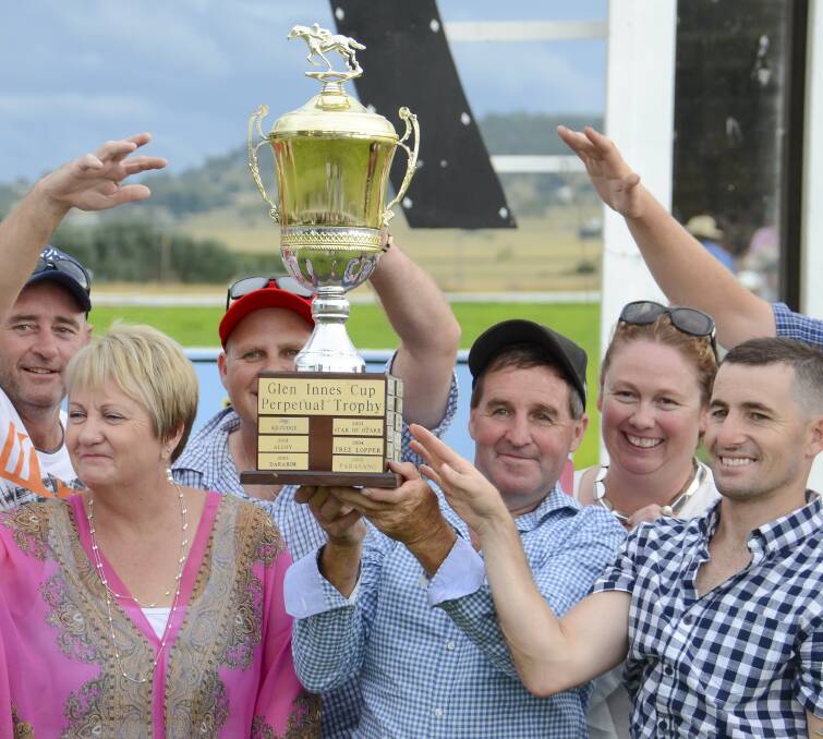 The joy of victory: Paddy Cunningham lifts the Glen Innes Cup with some happy connections on what was a big day for the hometown trainer. Photo: Tony Grant.
