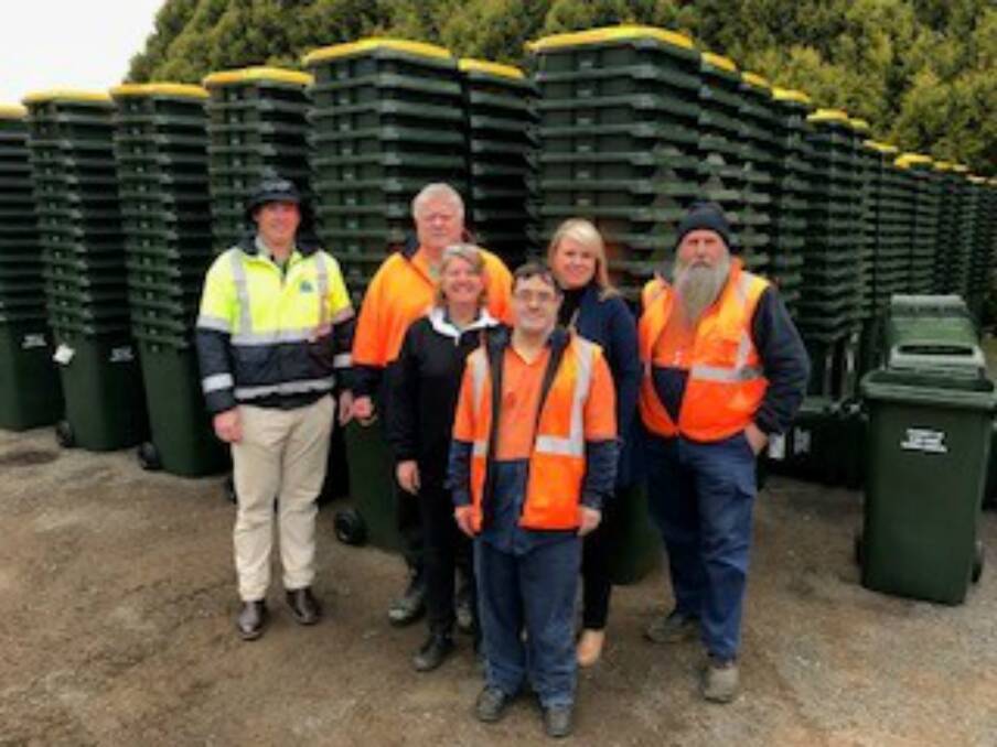 The new yellow-top bins with council and Glen Industries staff.