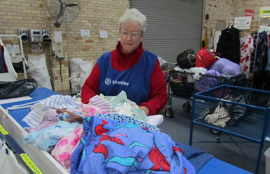 Maureen Campbell sorts clothes at the St Vincent de Paul Society shop, Vinnies, at 192, Bourke Street in Glen Innes.