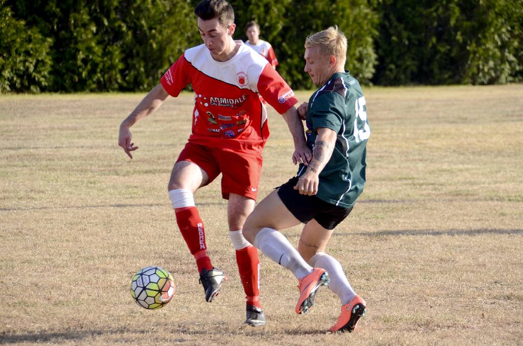 Dylan Ferris competing for the ball with a North Armidale player.