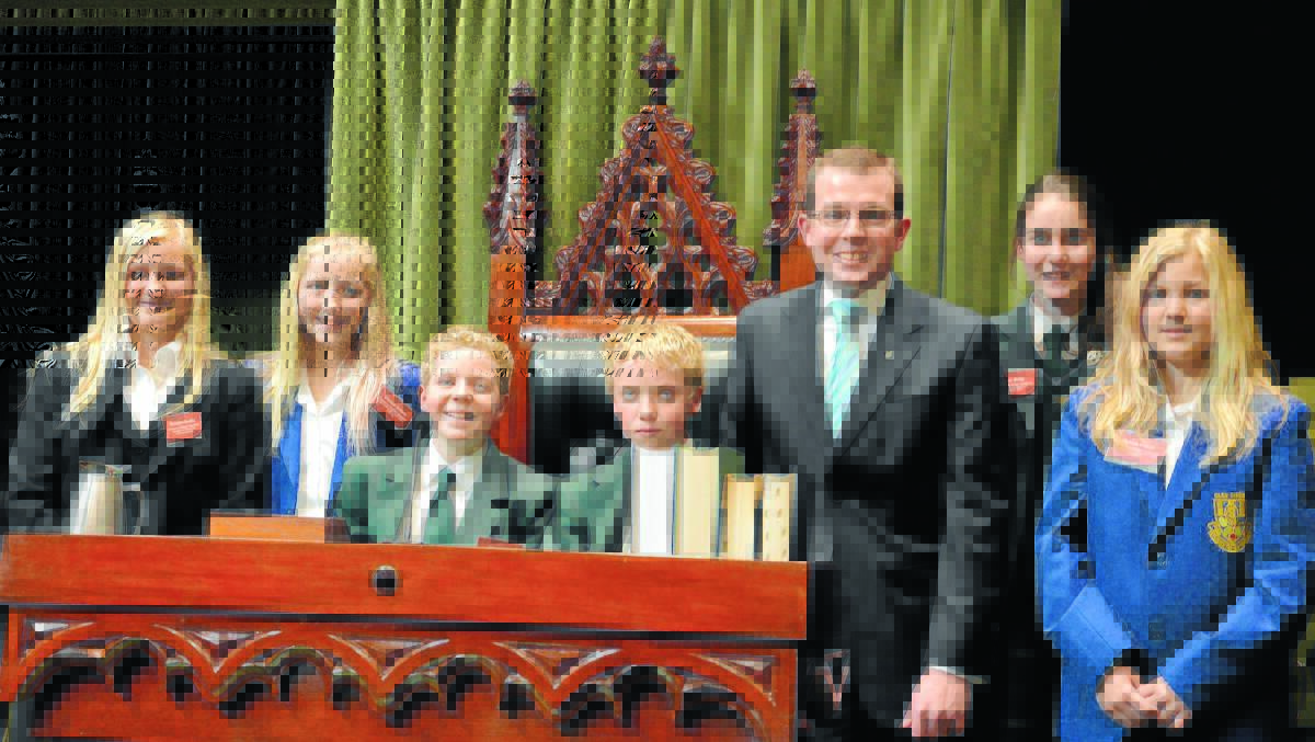 o Great debaters : Northern Tablelands Junior MPs pictured with their ‘senior’ colleague Adam Marshall around the Speaker’s Chair in the Legislative Assembly on Tuesday: (from left) Georgina Beattie and Chelsea Jenkins of Glen Innes, Adam Lucas and Bradley Lucas of Duval, Kate Biddle of PLC Armidale and Melinda Beattie of Glen Innes.