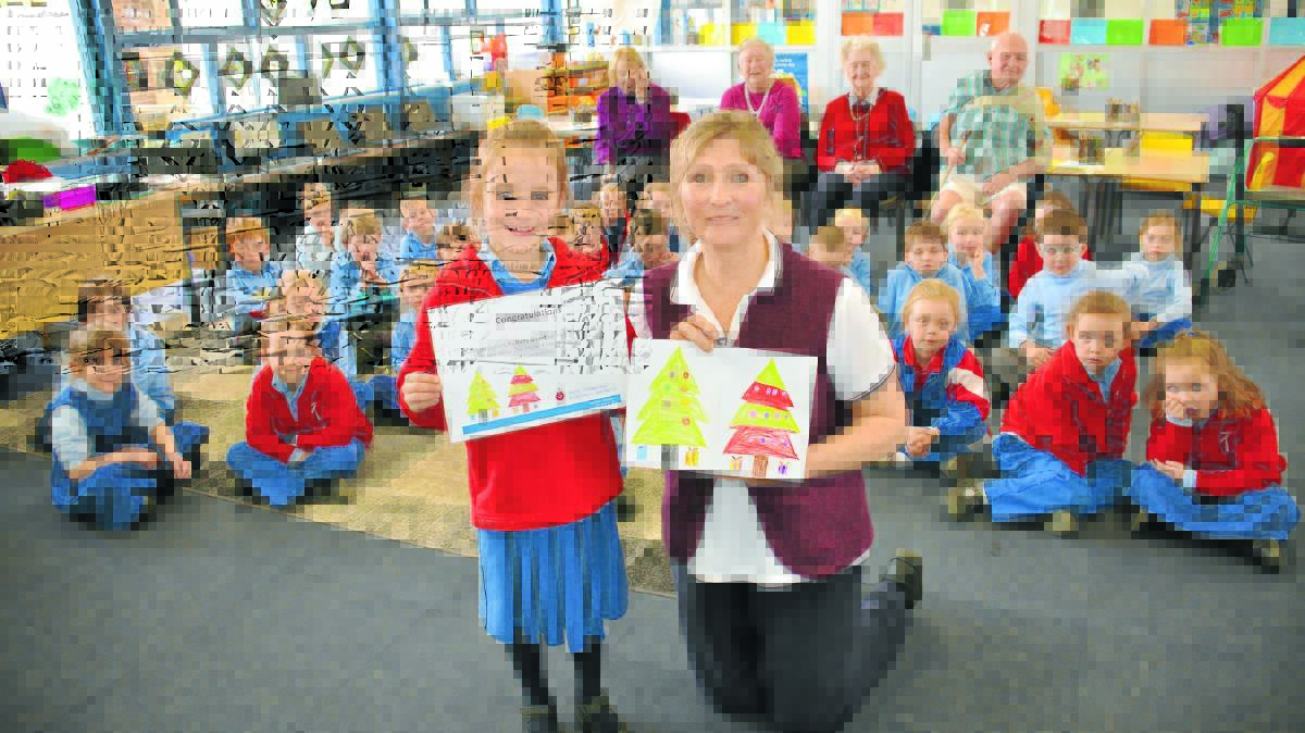 o Published artist: RFBI Glen Innes Masonic Village’s Janelle Gmyr thanks St Joseph’s kindy student Ruby Goard for her artwork which will adorn the village’s official Christmas card this year.