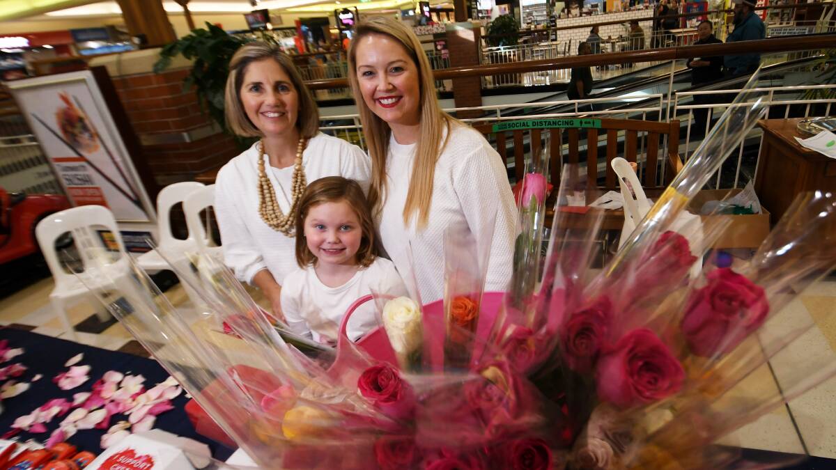 NURTURE: Joanne Jones, Lexi Bartlett, 8, and Tara Bartlett sold roses at Tamworth Shopping World on Friday to raise funds for cystic fibrosis research. Photo: Gareth Gardner