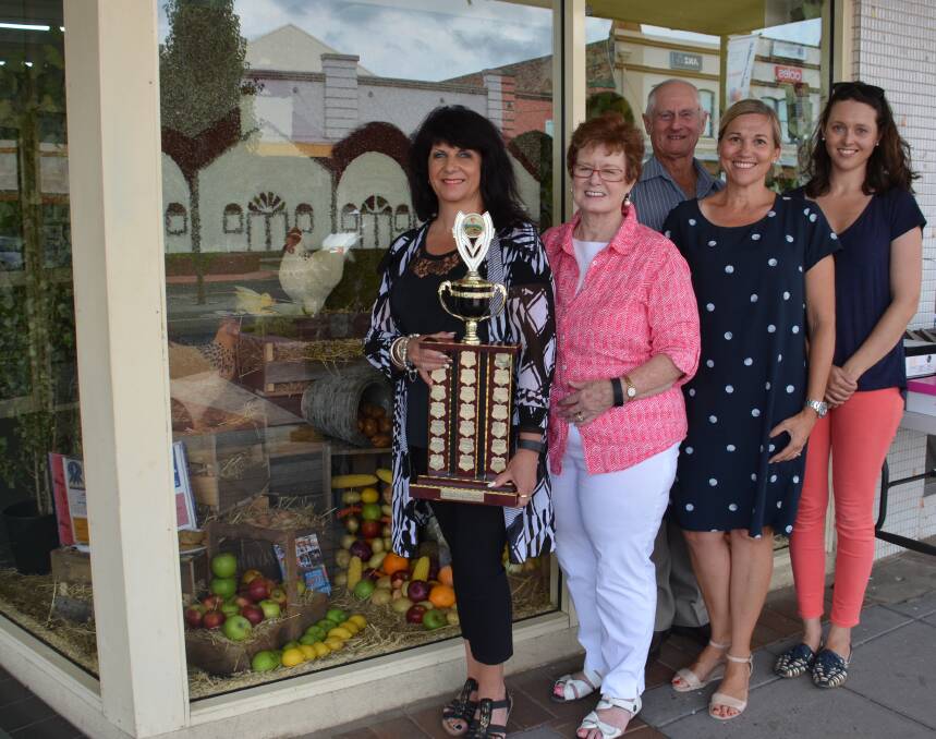 CHAMPION DISPLAY: Leanne Hamel holds the trophy for best window display. Looking on are Pattie Williamson, Dick Hartmann, Kate Dance and Renata Davis.