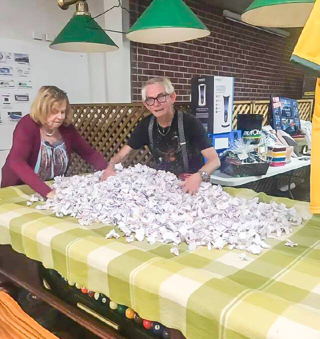 What a spread: People bought so many tickets for the monster raffle that the organisers - Sue Steel and James Kingdom are shown here - didn't have a receptacle big enough, and had to spread them out on a pool table for the draw.
