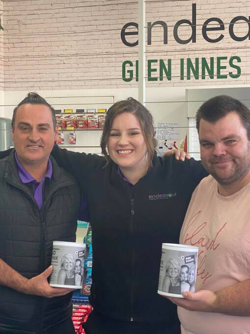 ALL FOR A GOOD CAUSE: Endeavour staff Christopher Marshall and Ben Brosi with store manager Jessica Wilkins and their donation tins this week . Photo supplied.