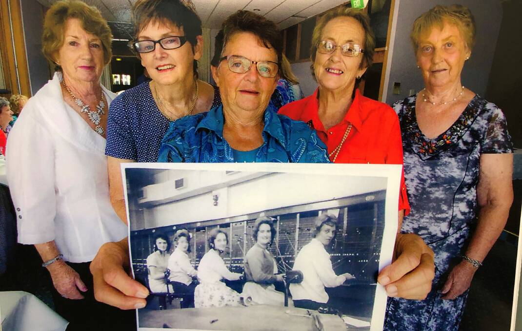 Lyn Giles, Gail Lee, Marie Romer, Carol Shannon and Amelia Winterton in 2016 with a photo from c. 1961 of the manual switchboard they operated. In the old photo is (from left) Gail Lee, Lyn Giles, Carol Shannon, Helen McBurnie and Amelia Talbot.