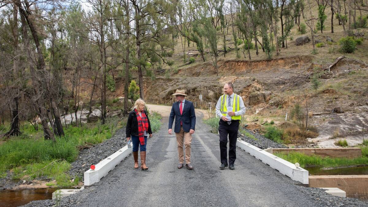 Glen Innes Severn Council Mayor Carol Sparks, Northern Tablelands MP Adam Marshall and Director of Infrastructure Services Keith Appleby walking across the temporary bridge at Wytaliba, which is about to be replaced by a $2.3 million concrete structure.
