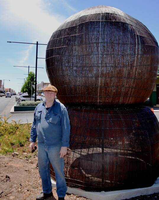 ART: Carl Cree standing next to his Balancing Rock sculpture