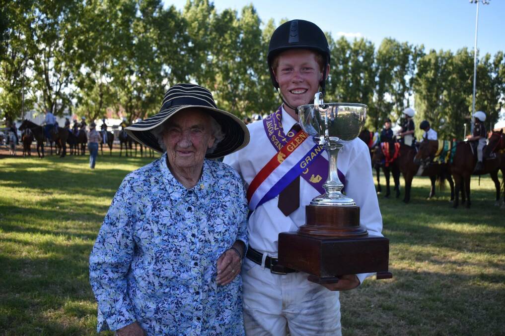 TOP HONOUR: Margaret Smith presented Luke Kiehne with the trophy for grand champion rider at the Glen Innes Pony Club competition on the weekend. Photo: Contributed.