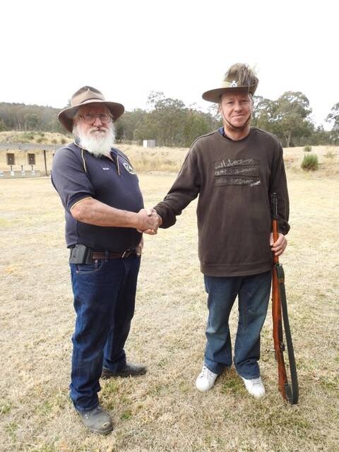SSAA Glen Innes President Evan Brown congratulates Kris Brown (right) for winning the ANZAC day shoot with his WW2 era rifle. 
