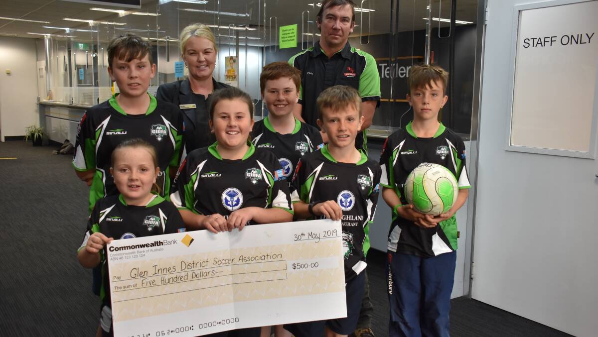 THE TEAM: Bridie Taylor, Mandy Crisp, Chris Wilson, Makaysha Taylor, Pixie Parkes, Toby Parks, Brock Taylor and Jaydan Taylor accept an unreasonably sized check from the Glen Innes Commonwealth bank branch.