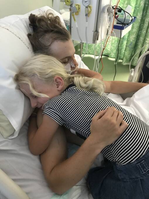 HAWTHORNE'S HELPERS: A family friend hugs Tom Hawthorne while on a visit to John Hunter Hospital in Newcastle where he is receiving care for a severe brain trauma.