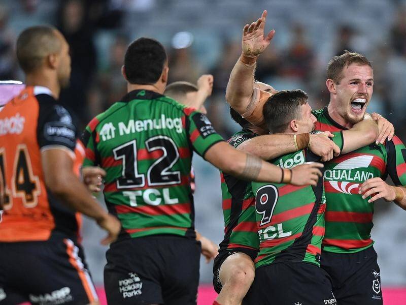 Tom Burgess celebrates after the match-winning try for Souths against the Tigers.