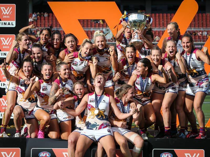 Brisbane players celebrate winning their first AFLW grand final at their third attempt.