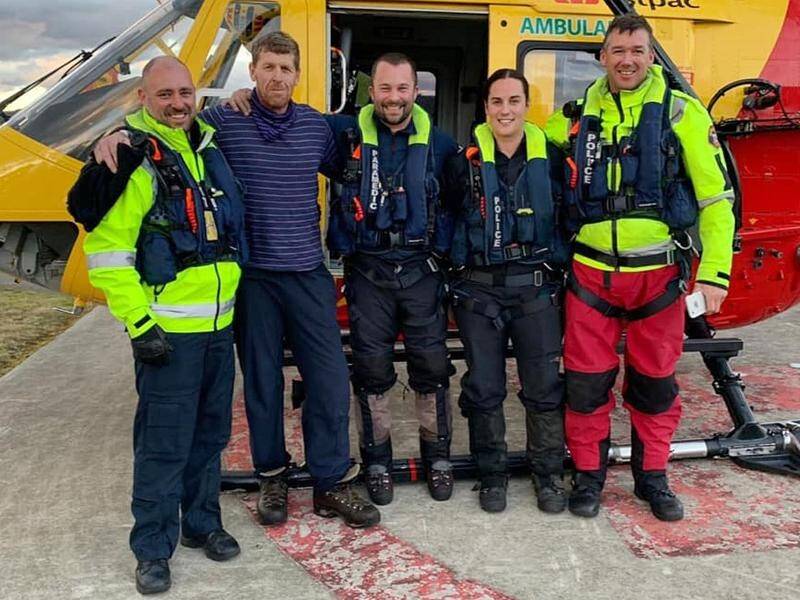Michael Bowman (second left) with his rescuers after being found alive and well in Tasmania.