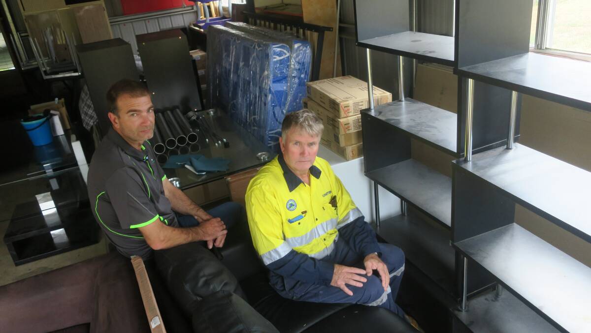 Tim Chard (left) of Pathfinders and Richard Edkins amidst the furniture stored in a garage.