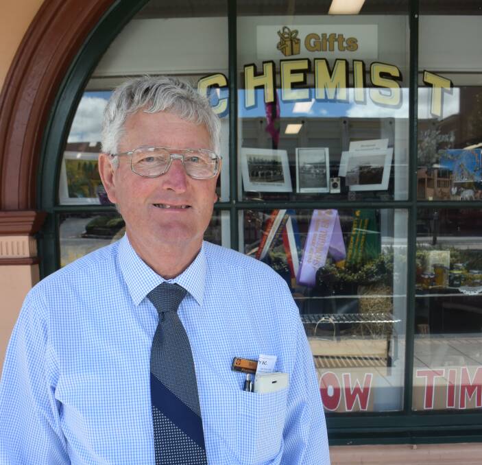 Bill Munro of Timbs Pharmacy which came joint second in the Glen Innes Show store display competition. The window display includes historic pictures.