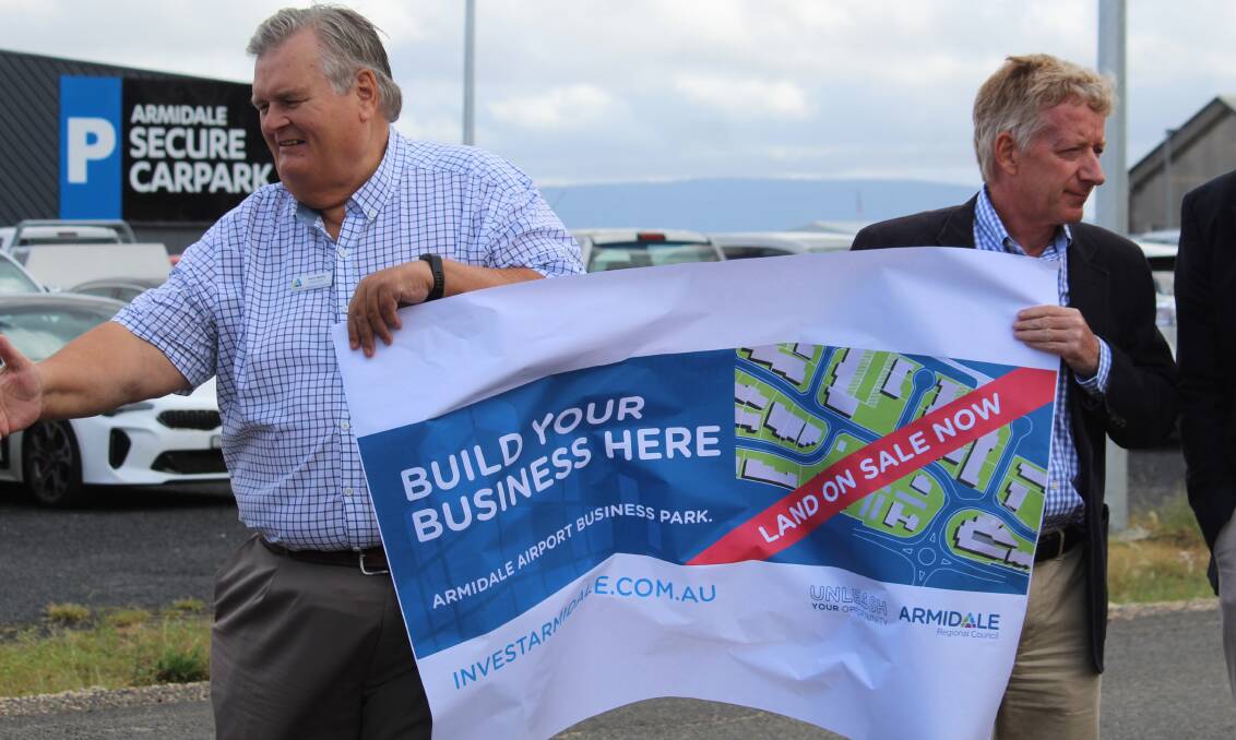 SLOGAN: Cr Peter Bailey and Tony Bloomfield hold a smaller version of the sign to be shortly displayed near the airport.