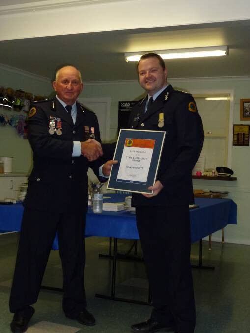NSW SES Commissioner Adam Dent presenting local volunteer Brian Barratt with life membership of the NSW State Emergency Service.