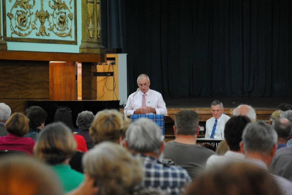 o Considered opinions: Glen Innes Severn Council’s Graham Price addresses the crowd at Tuesday night’s public meeting, chaired by mayor Colin Price.